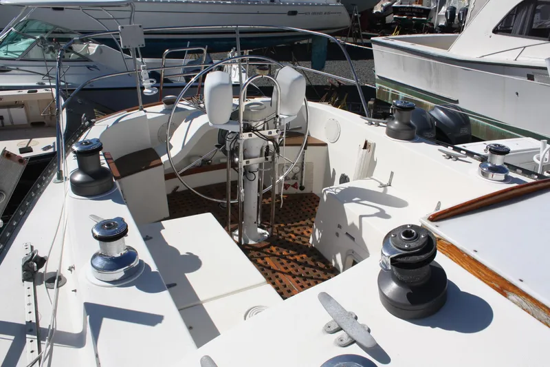 Slide: The Image of 1976 C&C 38 sailboat cockpit with steering wheel and winches, docked at marina. - 13