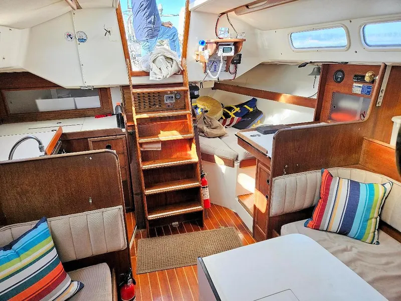 Slide: The Image of Interior of a 1976 C&C 38 sailboat with wooden finishes and colorful cushions. - 28