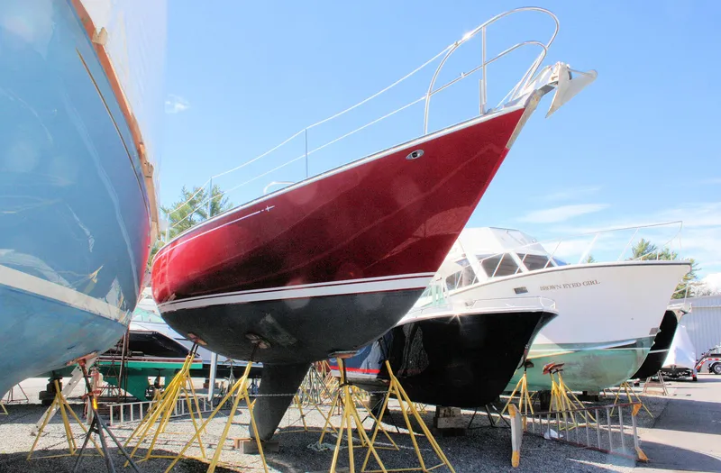 Slide: The Image of 1976 C&C 38 sailboat with red hull on stands in a boatyard. - 3