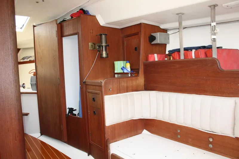 Slide: The Image of Interior of a 1976 C&C 38 sailboat with wooden cabinetry and white seating. - 35