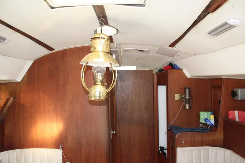 Slide: The Image of Interior of a 1976 C&C 38 sailboat with wooden paneling and brass lantern. - 36