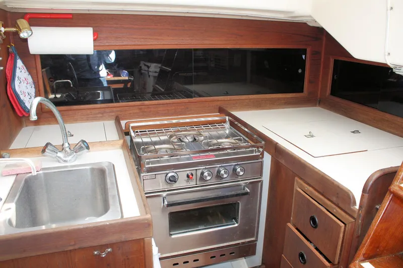 Slide: The Image of 1976 C&C 38 yacht kitchen with stove, sink, and wooden cabinetry. - 38