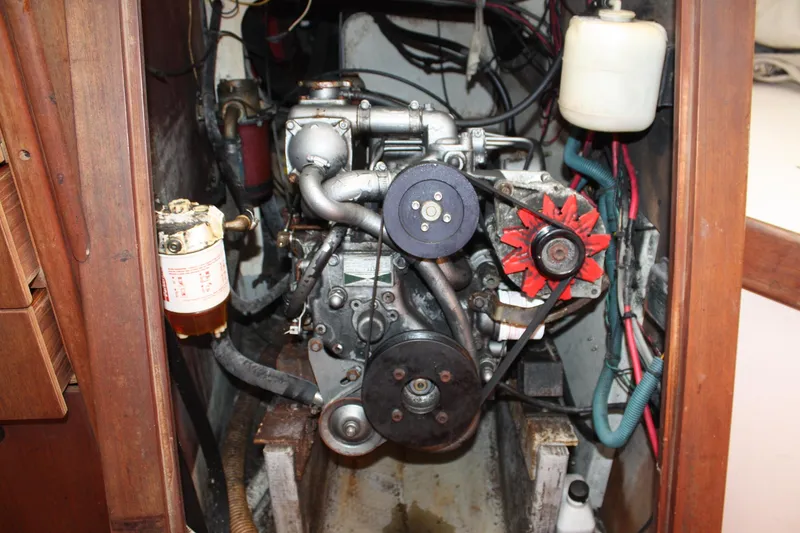Slide: The Image of Engine compartment of a 1976 C&C 38 sailboat, featuring mechanical components and wiring. - 43