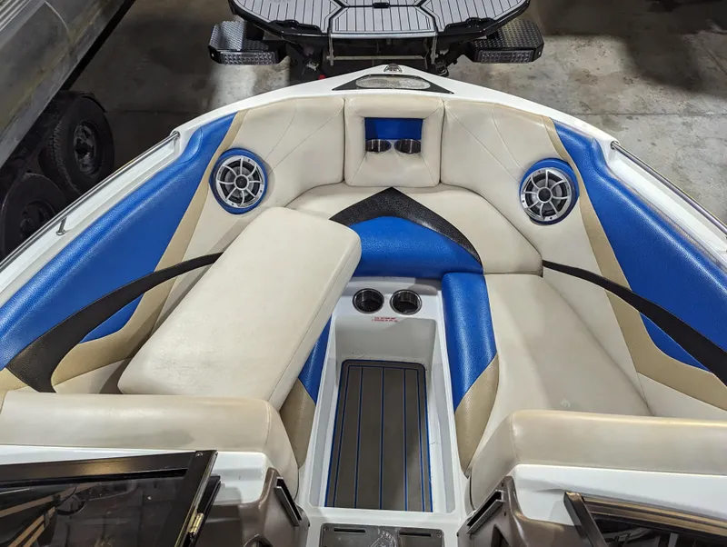 Slide: The Image of 2014 Centurion Enzo SV233 boat interior with blue and beige seating, speakers, and cup holders. - 10