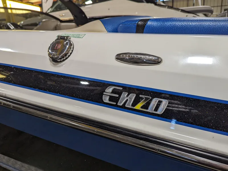 Slide: The Image of 2014 Centurion Enzo SV233 boat with blue and white detailing in a showroom. - 23