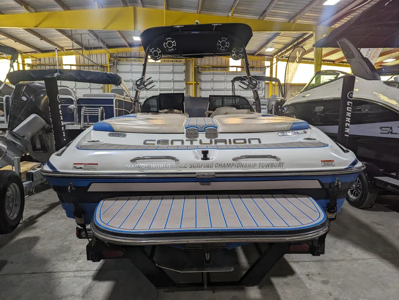 Slide: The Image of 2014 Centurion Enzo SV233 boat in a warehouse, rear view with wakeboard tower. - 3