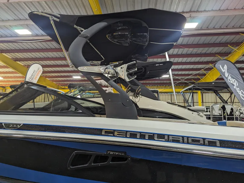 Slide: The Image of 2014 Centurion Enzo SV233 boat with sleek design and modern features in a showroom. - 5