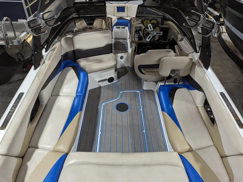 Slide: The Image of 2014 Centurion Enzo SV233 boat interior with beige and blue seating, modern dashboard, and spacious layout. - 7