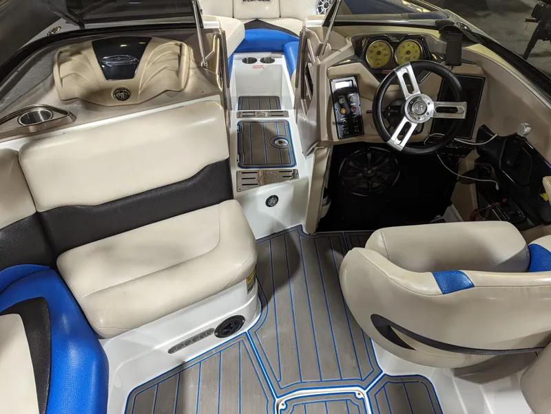 Slide: The Image of 2014 Centurion Enzo SV233 boat interior with beige and blue seating, modern dashboard, and steering wheel. - 9