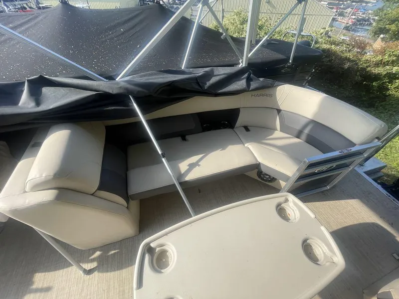Slide: The Image of 2021 Harris CRUISER 250 CW P3 pontoon boat interior with beige seating and table. - 10