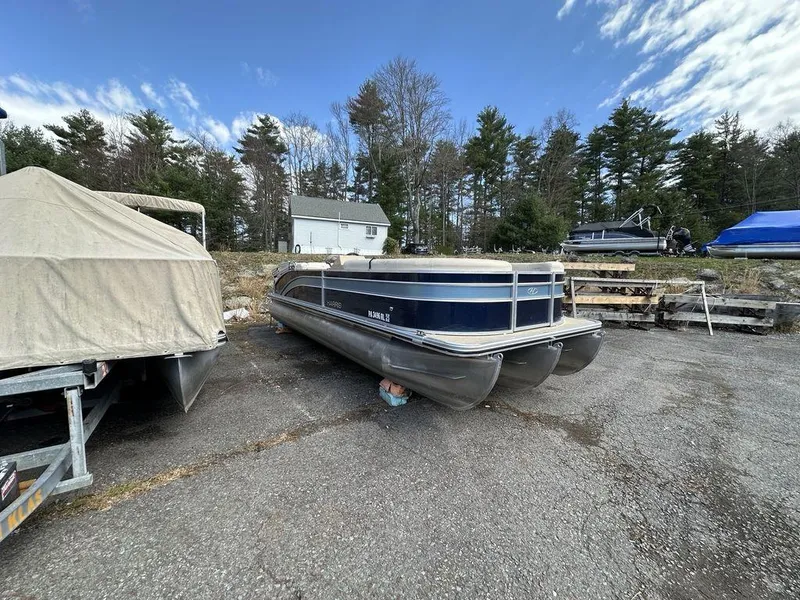Slide: The Image of 2021 Harris CRUISER 250 CW P3 pontoon boat parked outdoors. - 11