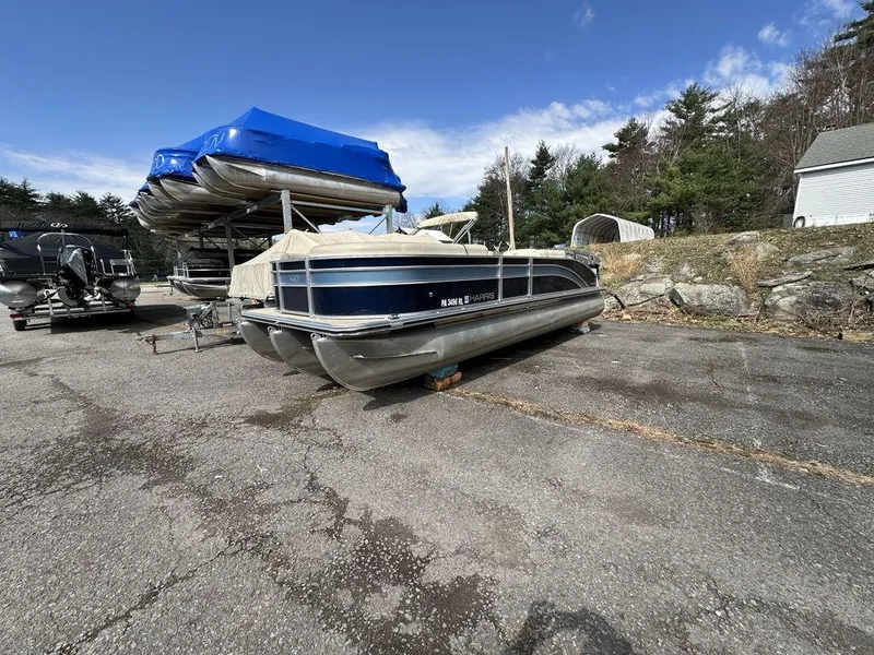 Slide: The Image of 2021 Harris CRUISER 250 CW P3 pontoon boat parked outdoors on a sunny day. - 13