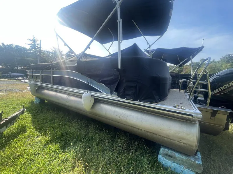 Slide: The Image of 2021 Harris CRUISER 250 CW P3 pontoon boat with canopy on grass. - 2