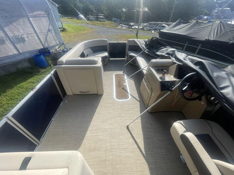 Slide: The Image of 2021 Harris CRUISER 250 CW P3 pontoon boat interior with beige seating and steering console. - 5