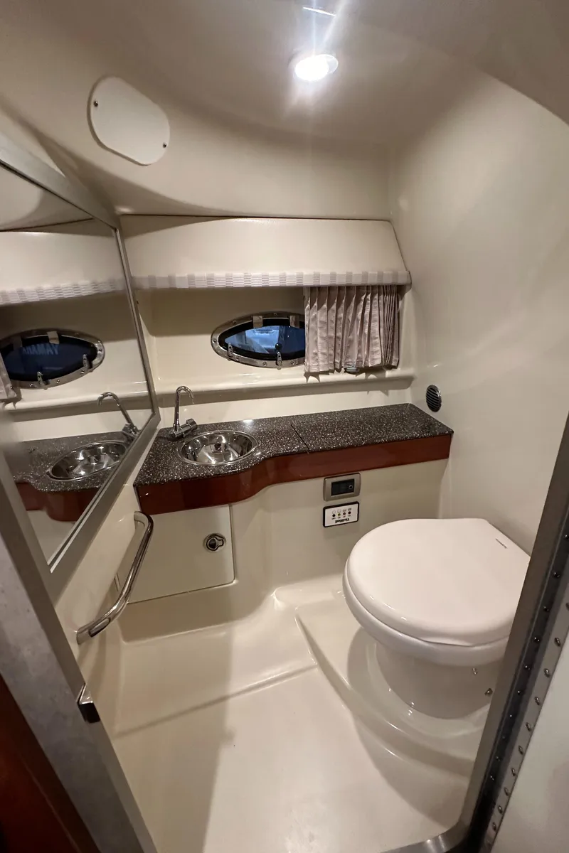 Slide: The Image of 2007 Formula 310 Sun Sport boat bathroom with sink, toilet, and porthole window. - 18