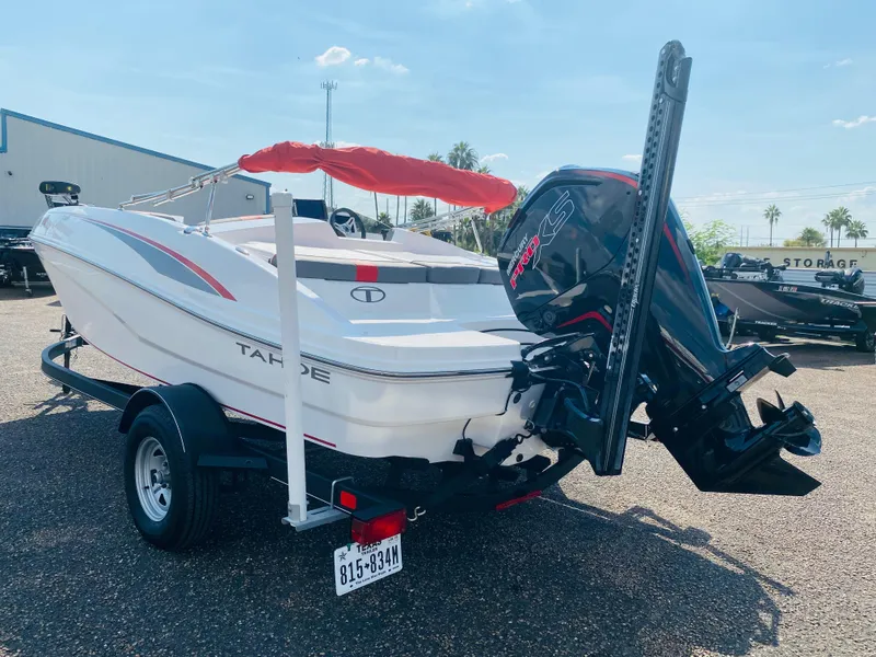 Slide: The Image of 2024 Tahoe T18 boat with outboard motor on trailer, parked outdoors. - 4