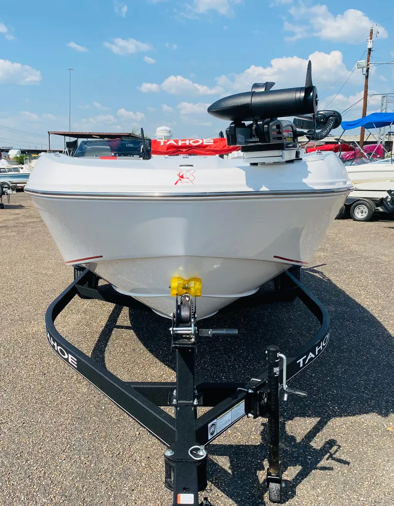 Slide: The Image of 2024 Tahoe T18 boat on trailer, parked outdoors under a clear sky. - 5
