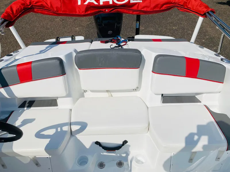 Slide: The Image of 2024 Tahoe T18 boat interior with red and gray seating, steering wheel, and controls. - 8