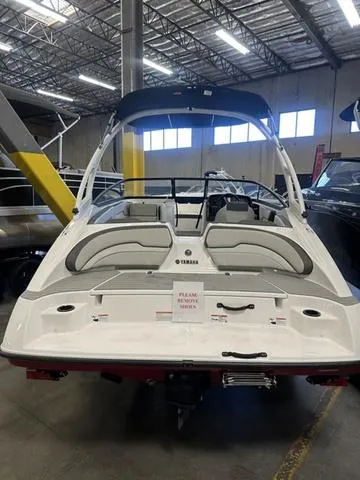 Slide: The Image of 2024 Yamaha AR190 boat in showroom, rear view with seating and canopy. - 3