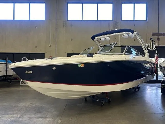 Slide: The Image of 2020 Cobalt R7 Surf boat in showroom, sleek design, navy and white exterior. - 4