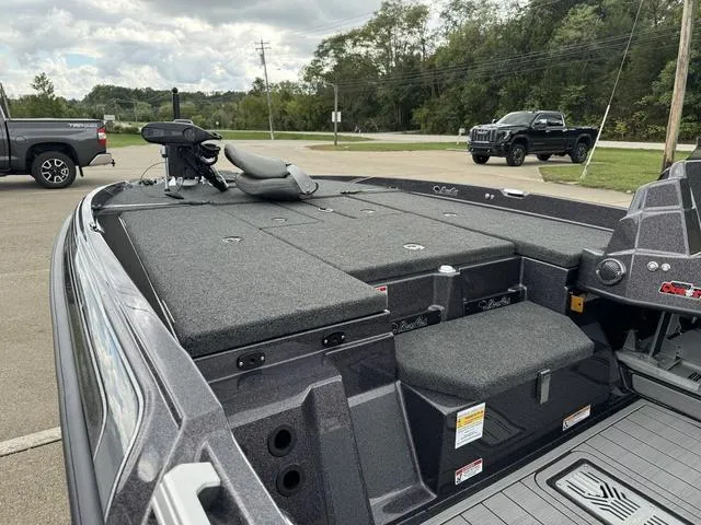 Slide: The Image of 2025 Bass Cat Puma STS boat with spacious deck and seating in a parking lot. - 12