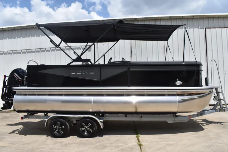 The Image of 2025 Lowe LS210WT TL pontoon boat with canopy, parked on a trailer. - 0