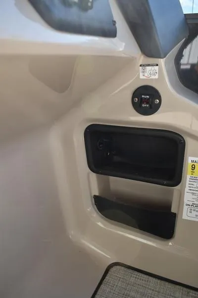 Slide: The Image of Interior view of 2025 Lowe LS190 boat, featuring storage compartment and control panel. - 21