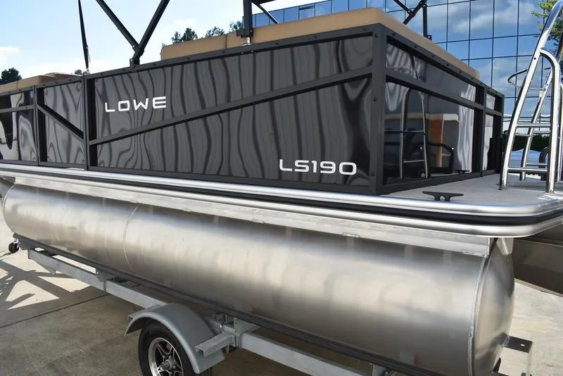 Slide: The Image of 2025 Lowe LS190 pontoon boat on trailer, sleek design, reflective surface. - 3