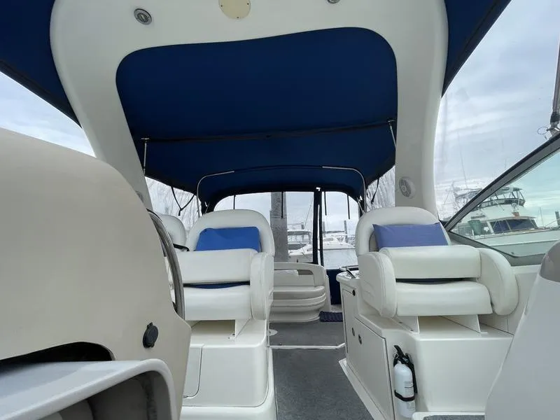 Slide: The Image of Interior of 2003 Sea Ray 340 Sundancer boat with blue canopy and white seating. - 11
