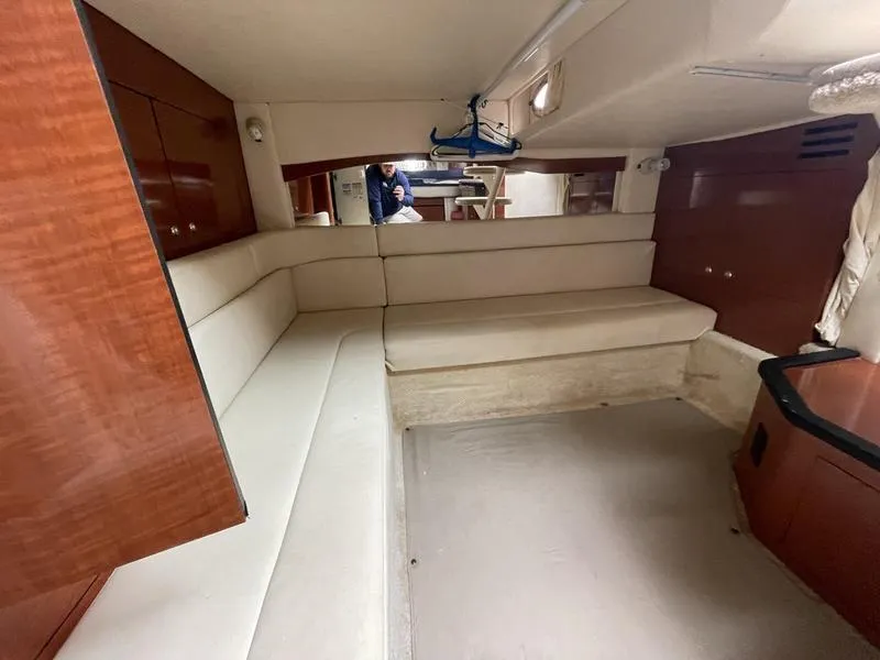 Slide: The Image of Interior of 2003 Sea Ray 340 Sundancer with beige seating and wooden cabinetry. - 8