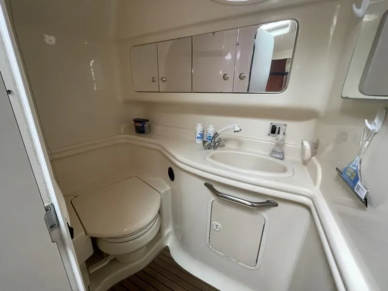 Slide: The Image of 2003 Sea Ray 340 Sundancer bathroom with sink, toilet, and storage cabinets. - 9