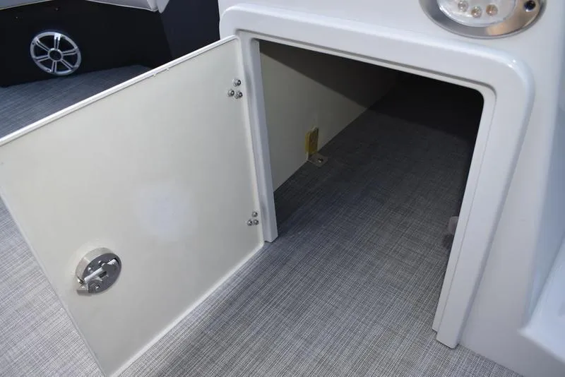 Slide: The Image of Open storage compartment on 2023 Lowe SS 210 DL boat, featuring gray flooring. - 29