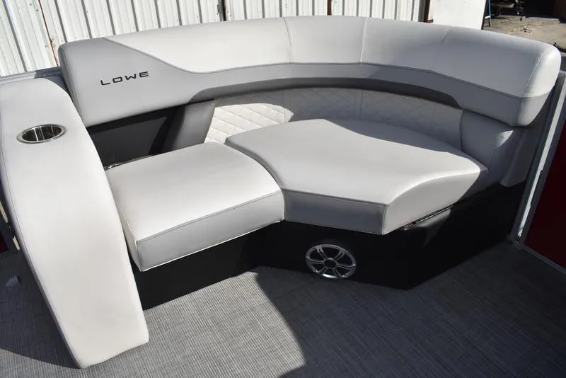 Slide: The Image of 2023 Lowe SS 210 DL pontoon boat interior with plush seating and cup holders. - 7