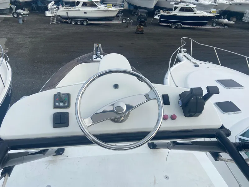 Slide: The Image of Steering wheel of a 2011 Sabre Custom Yachtfish, docked among other boats. - 12