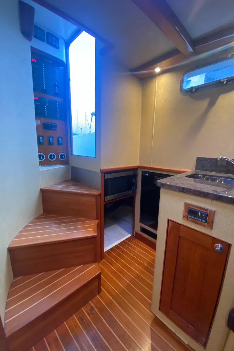 Slide: The Image of Interior of 2011 Sabre Custom Yachtfish with wooden stairs and modern kitchen area. - 18