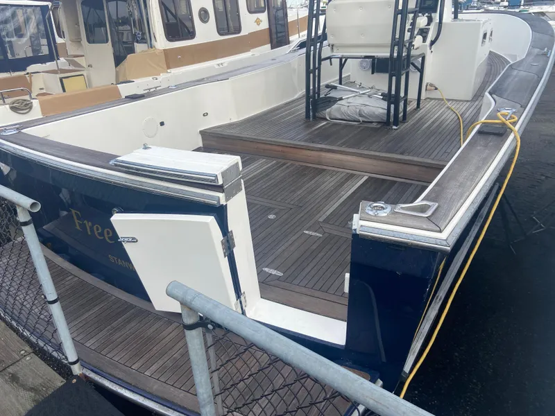 Slide: The Image of 2011 Sabre Custom Yachtfish with spacious deck and seating area, docked at marina. - 3