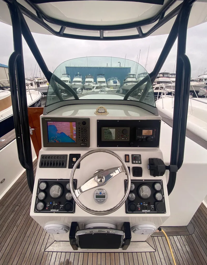 Slide: The Image of 2011 Sabre Custom Yachtfish helm with navigation controls and steering wheel. - 8