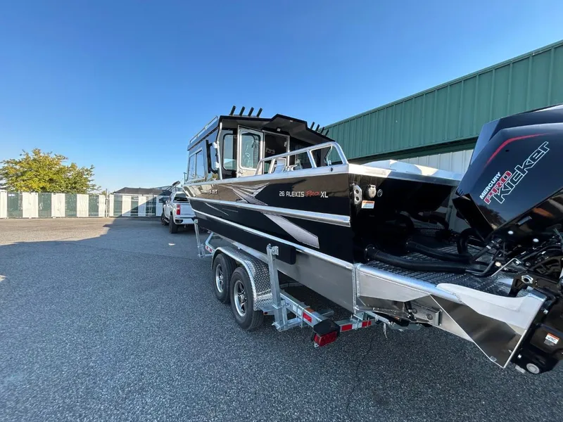Slide: The Image of 2025 Thunder Jet Alexis Pro XL 26' boat on trailer, parked outdoors. - 11