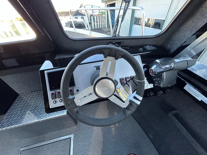 Slide: The Image of 2025 Thunder Jet Alexis Pro XL 26' boat cockpit with steering wheel and control panel. - 18