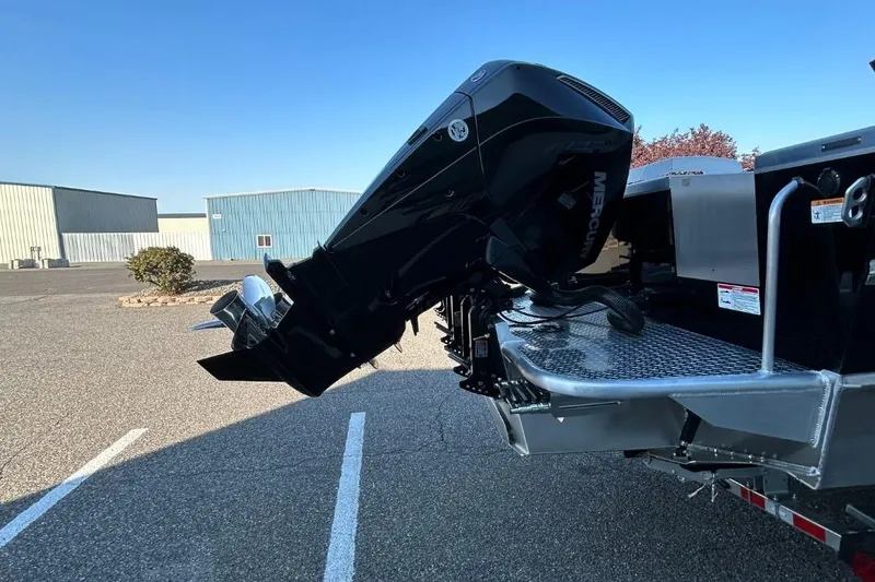 Slide: The Image of 2025 Thunder Jet Alexis Pro XL 26' boat with powerful outboard motor in parking lot. - 26