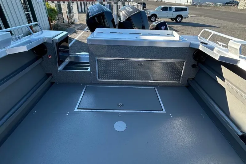 Slide: The Image of 2025 Thunder Jet Alexis Pro XL 26' boat interior with storage compartments and dual engines. - 29