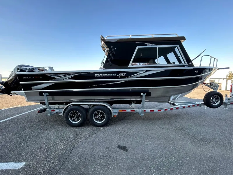 Slide: The Image of 2025 Thunder Jet Alexis Pro XL 26' boat on trailer, sleek black design. - 3