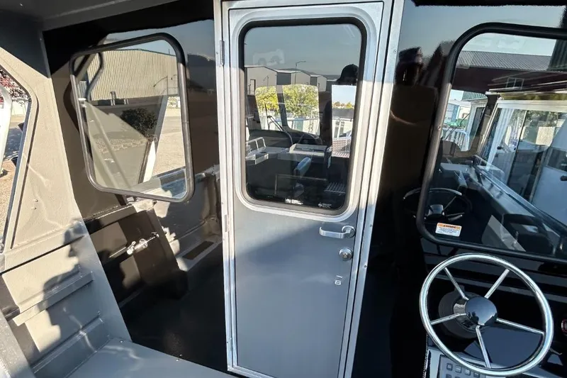 Slide: The Image of 2025 Thunder Jet Alexis Pro XL 26' boat interior with steering wheel and door. - 39
