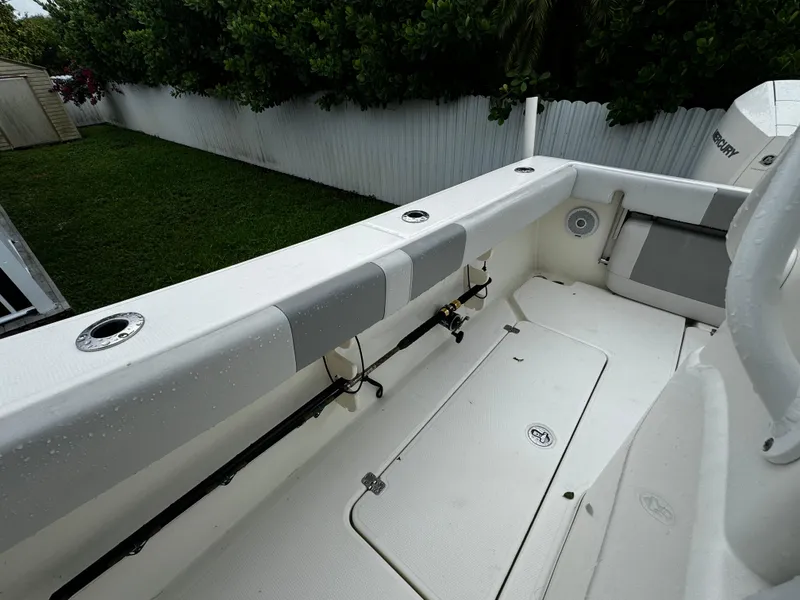 Slide: The Image of 2020 Mako 284 CC boat interior with rod holders and storage compartments. - 14