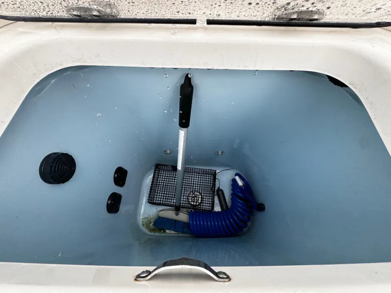 Slide: The Image of Livewell in 2020 Mako 284 CC boat, featuring blue interior and equipment. - 16