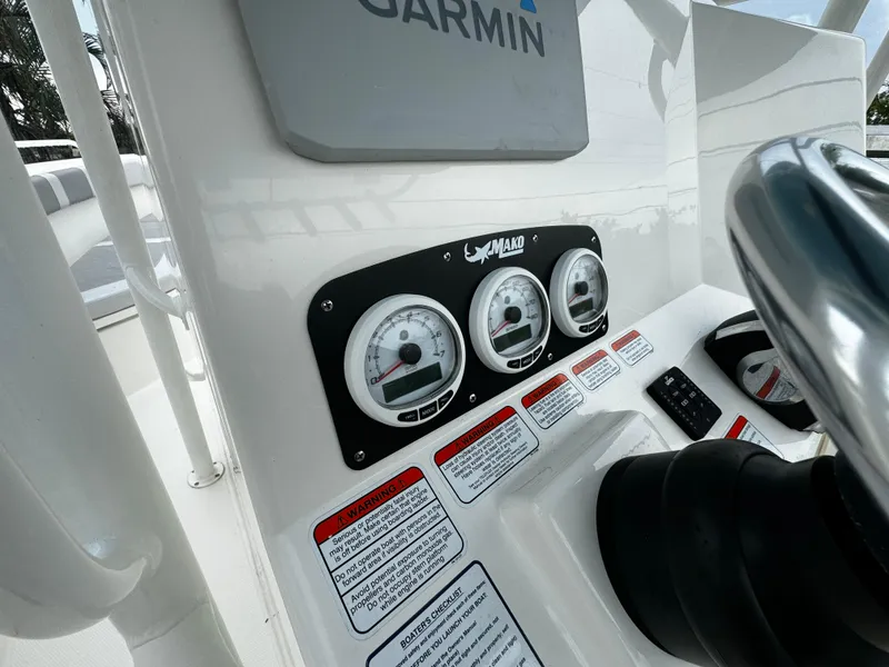 Slide: The Image of Mako 284 CC 2020 boat dashboard with gauges and Garmin equipment. - 19