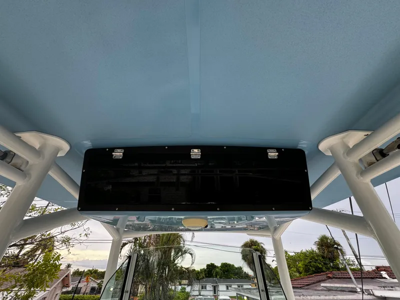 Slide: The Image of 2020 Mako 284 CC boat interior with blue ceiling and storage compartment. - 21