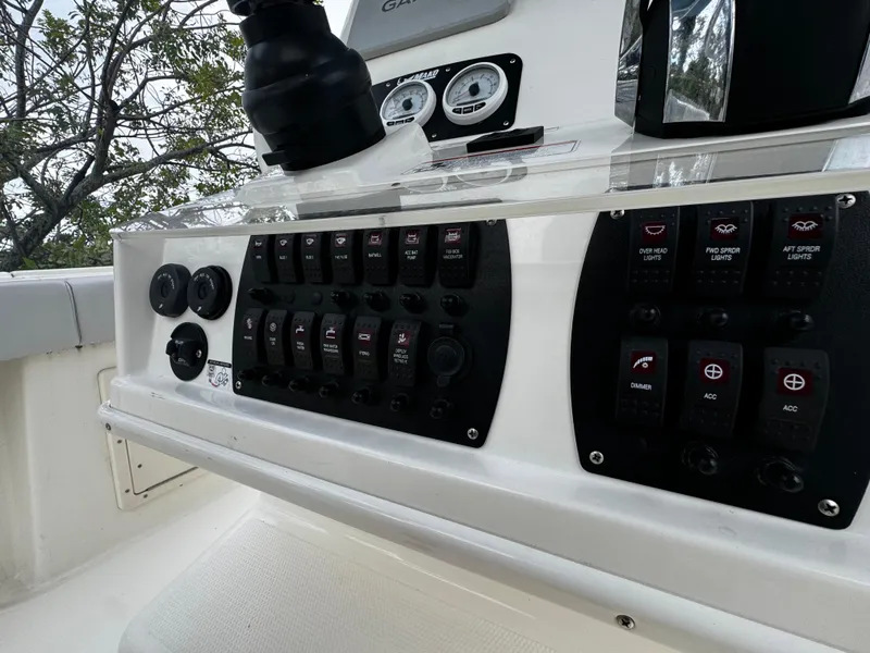 Slide: The Image of Control panel of 2020 Mako 284 CC boat with switches and gauges. - 24