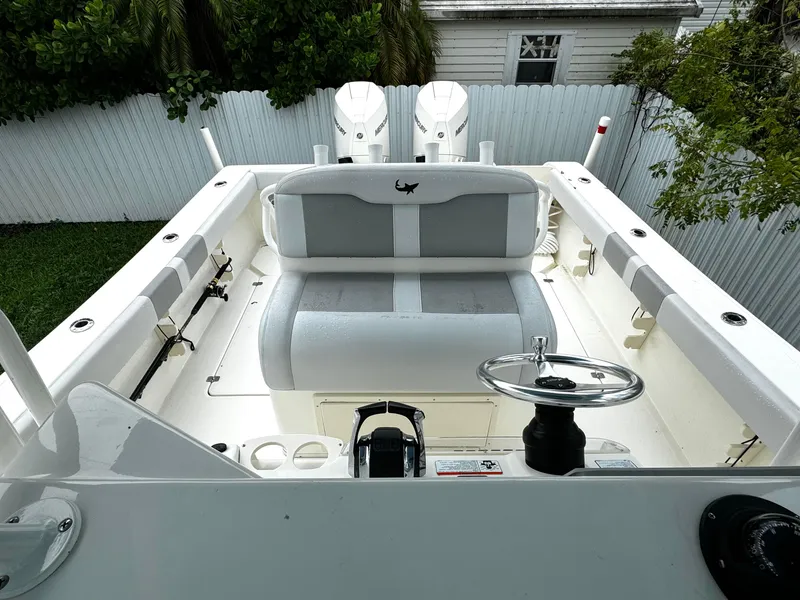Slide: The Image of 2020 Mako 284 CC boat interior with dual engines and seating area. - 25