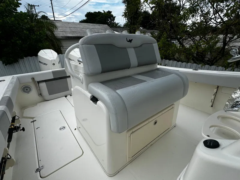 Slide: The Image of 2020 Mako 284 CC boat interior with cushioned seating and storage. - 28